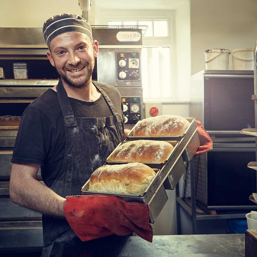 A baker with the morning’s loaves. Photograph by Andy Gallacher Photography.