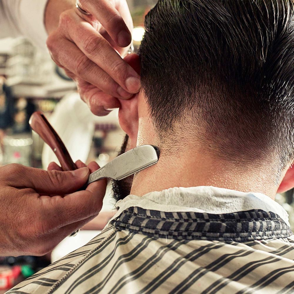 A barber finishing a cut. Photograph by Andy Gallacher Photography.
